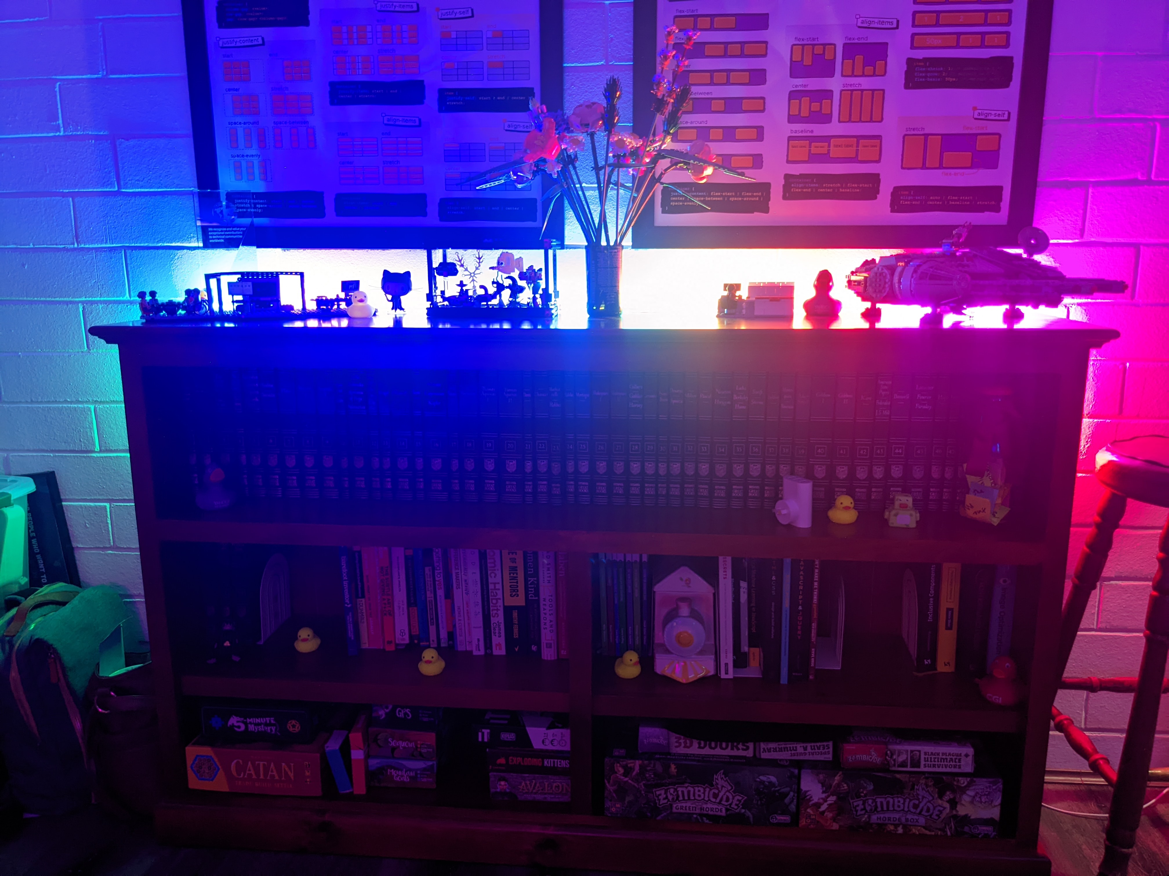 A similar photo of the bookshelf, this time dimly list to show the LED lights mounted on the back of the shelf